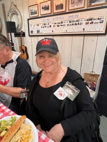 Sandy-Bakke-dressed-in-her-crab-hat.-Ken-Bakke-is-in-the-background-enjoying-the-delicious-crab